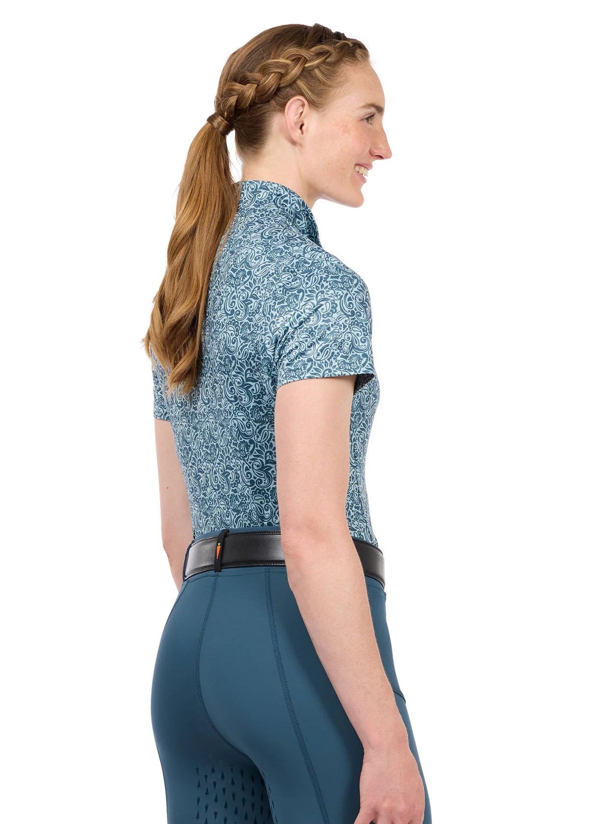 Woman wearing a blue short sleeve riding shirt, angled rear view