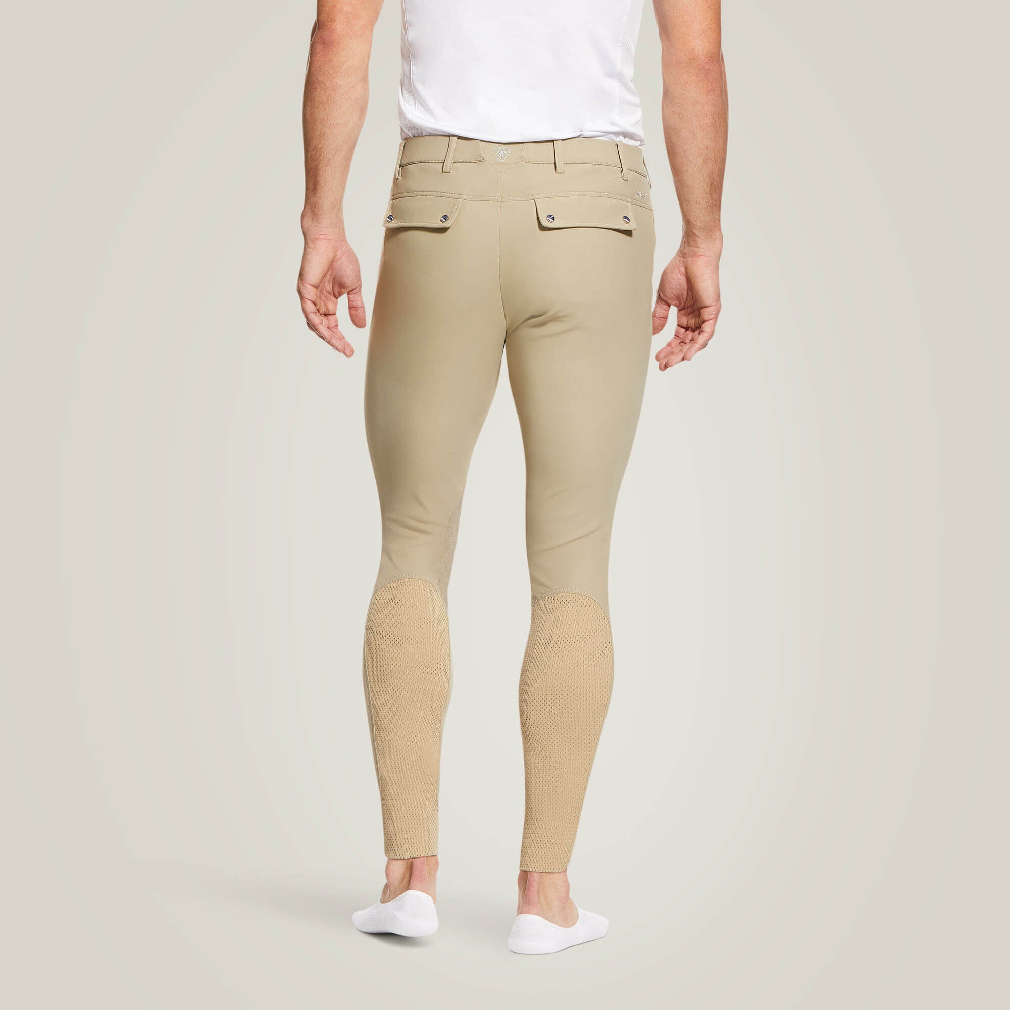 Back view of a male model wearing the Tan Ariat Men's Tri Factor Knee Patch Breeches on a plain background