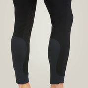 Back view of the mesh calf on the Black Ariat Men's Tri Factor Knee Patch Breeches as worn by a male model on a plain background