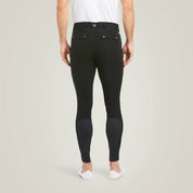 Back view of a male model wearing the Black Ariat Men's Tri Factor Knee Patch Breeches on a plain background