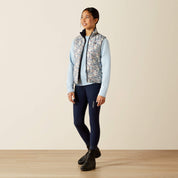 Full body front view of a young female model wearing the Posey Pony Print Ariat Youth Bella Reversible Insulated Vest with blue breeches on a plain background