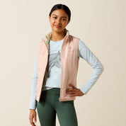 Front view of a young female model wearing the Horse In Flowers/Sepia Rose Ariat Youth Bella Reversible Insulated Vest on a plain background