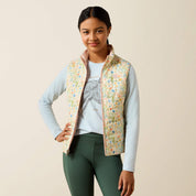 Front view of a young female model wearing the Horse In Flowers/Sepia Rose Ariat Youth Bella Reversible Insulated Vest on a plain background