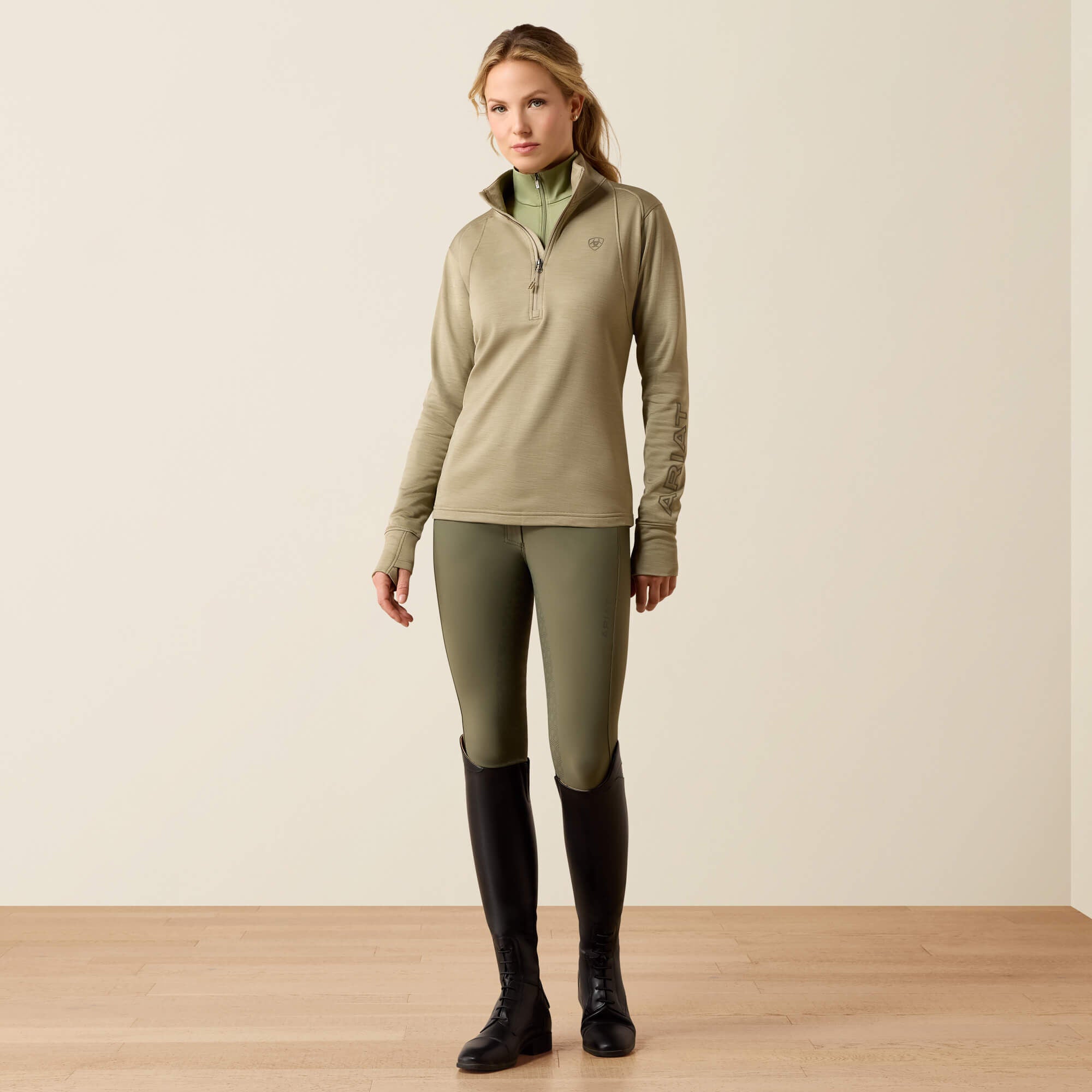 Front view of a model wearing the Winter Twig Ariat Team EQ 1/2 Zip Pullover on a plain background