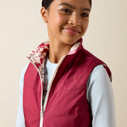 Close-up front view of a young female model wearing the Vanilla Ice Horsin' Around Ariat Youth Bella Reversible Insulated Vest on a plain background