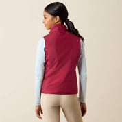 Back view of a young female model wearing the Vanilla Ice Horsin' Around Ariat Youth Bella Reversible Insulated Vest on a plain background
