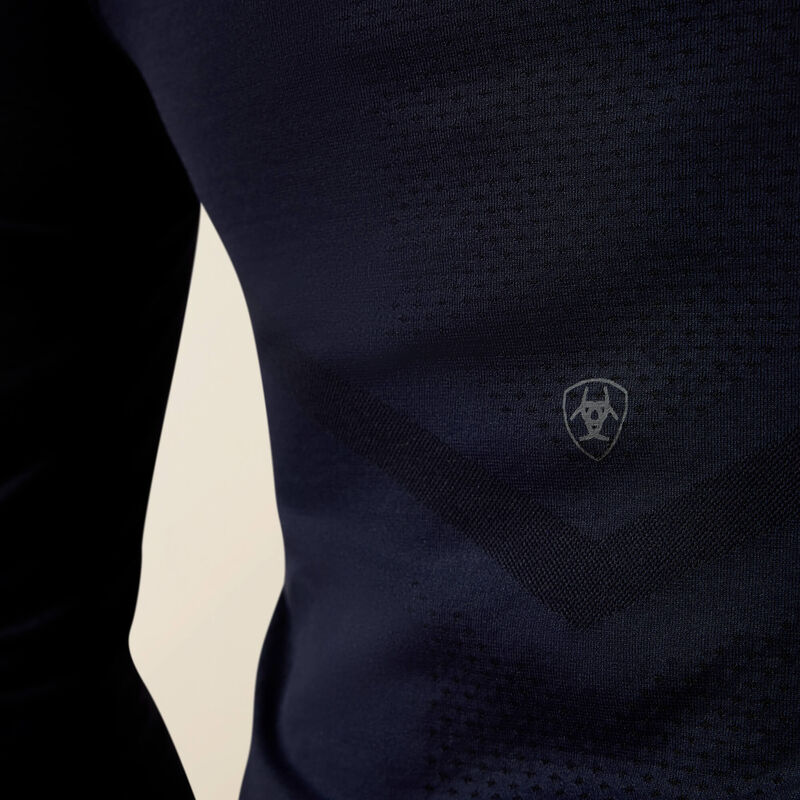 Back closeup view of a model wearing the Show Navy Ariat Sustain Long Sleeve Baselayer showing the Ariat logo