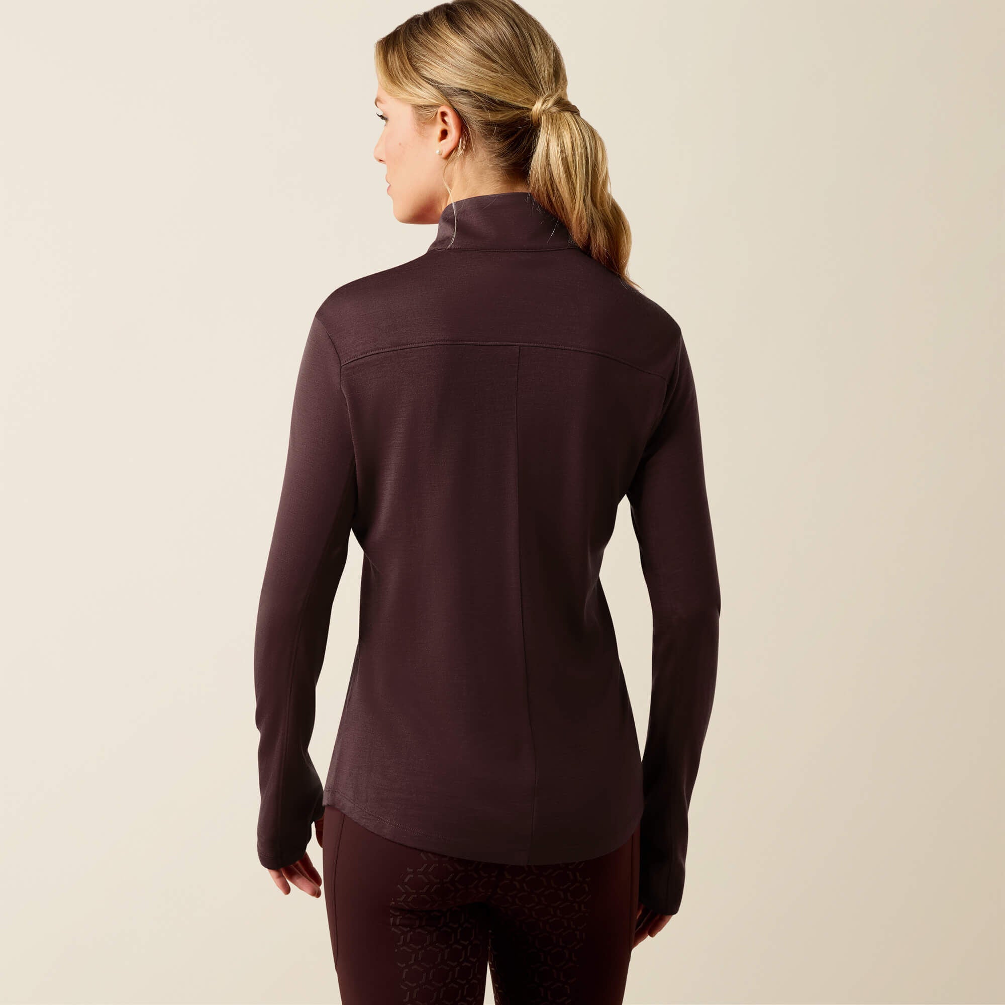 Back view of a female model wearing the Chocolate Plum Ariat Cheviot 1/4 Zip Long Sleeve Baselayer on a plain background