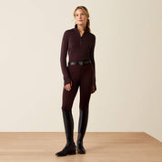 Full body front view of a female model wearing the Chocolate Plum Ariat Cheviot 1/4 Zip Long Sleeve Baselayer with coordinating breeches on a plain background