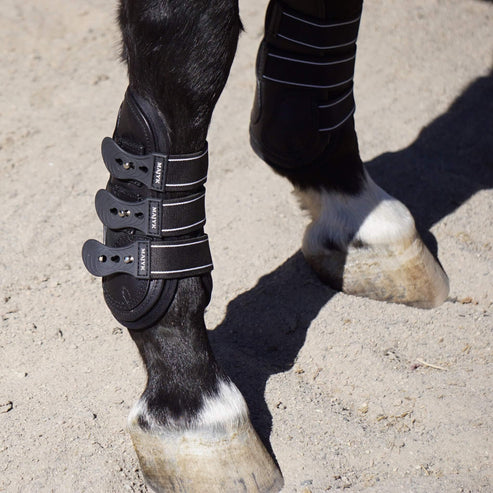 Close-up of a horse’s lower leg wearing a Majyk Equipe Boyd Martin leather tendon boot