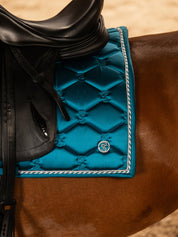 Close-up view of the logo and trim on the Evening Teal PS of Sweden Signature Dressage Pad as worn by a horse