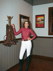 Front view of a female model wearing the cherry blossom Criniere Kai Shirt while standing in a tack room