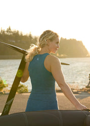 Woman wearing Kerrits Printed Sport Tank in Jasper blue outdoors near water, back view