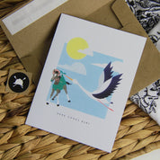 Front view of the Here Comes Baby Hunt Seat Paper Co. Greeting Card with its envelope