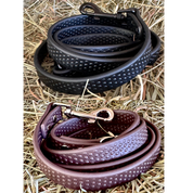 View of a black and a brown PRO4MANCE Com4rt Grip Dog Leash on hay