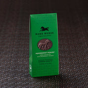 View of the Harbor Sweets Chocolate Peppermint Ponies Gable Box on a dark colored carpet background
