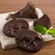 View of the chocolate ponies from the Harbor Sweets Chocolate Peppermint Ponies Gift Box on a wood background