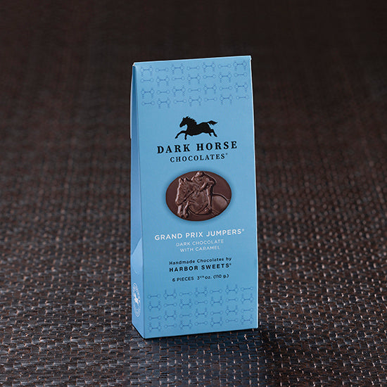 View of the 6 piece Harbor Sweets Chocolate Grand Prix Jumpers Gable box on a dark-colored carpet background