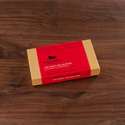 View of the 8 piece Harbor Sweets Milk Chocolate Hunt Collection gift box on a wood background