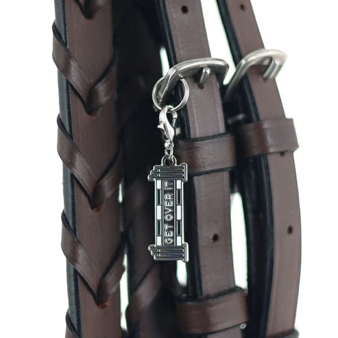 View of the Get Over it Dapplebay Bridle Charm on a brown bridle on a white background