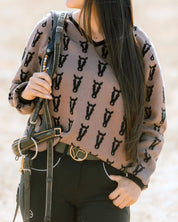 Front view of a female model wearing the Saddle/Black Deinhardt Designs Varsity Sweater while standing outside