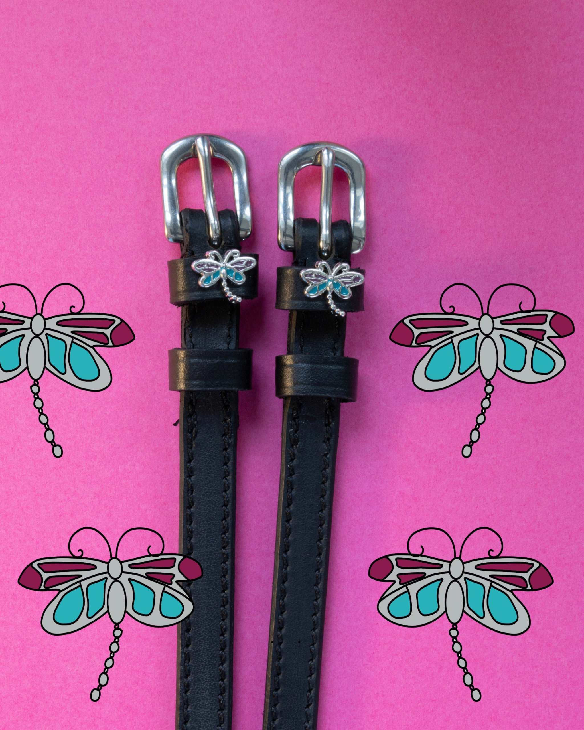 View of the Dragonfly Mane Jane Spur Straps on a pink dragonfly pattern backround