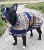 View of a boston terrier wearing the 5/A Baker Bakerfleece Dog Blanket while standing on a path outside