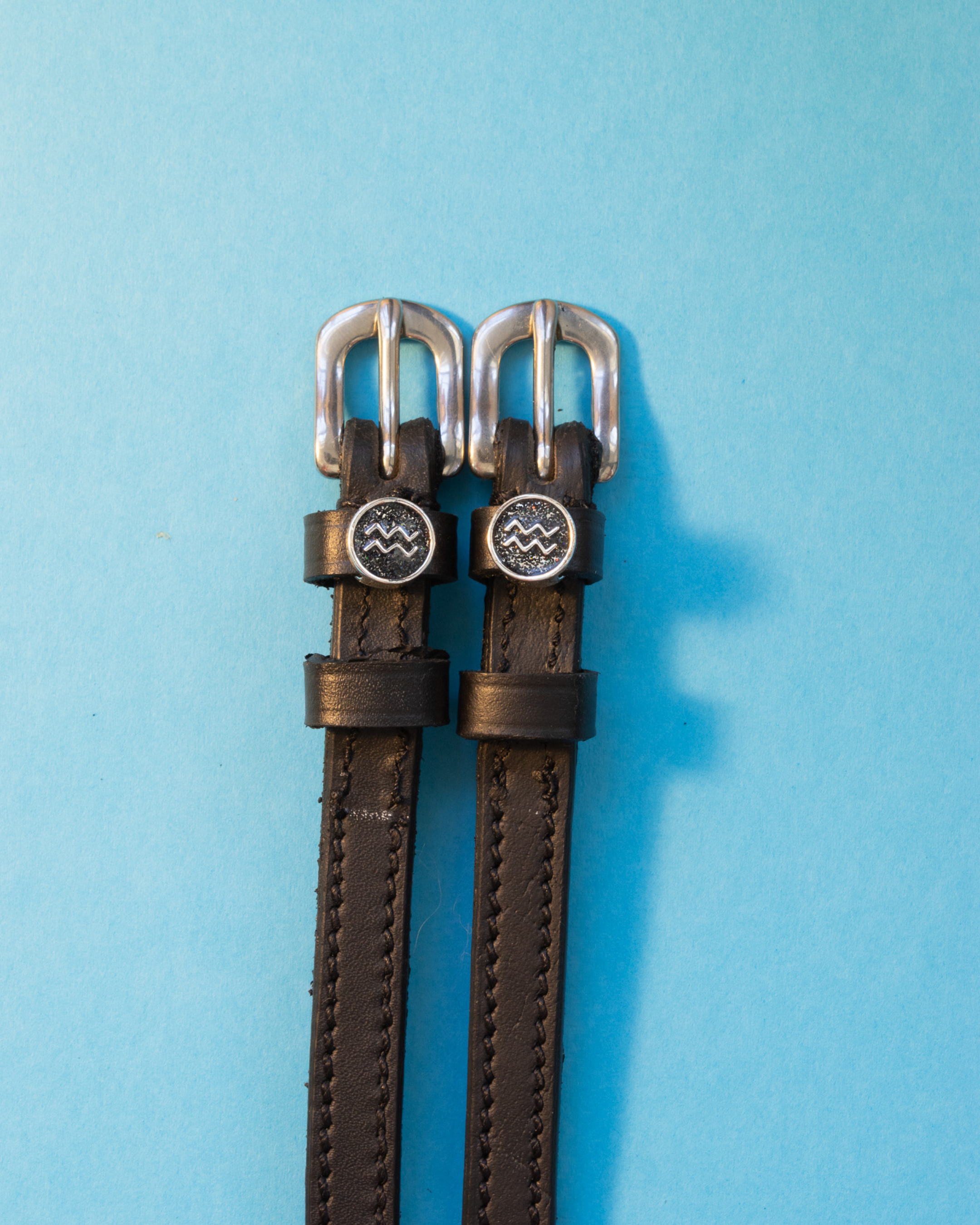 View of the Aquarius Mane Jane Spur Straps on a blue background