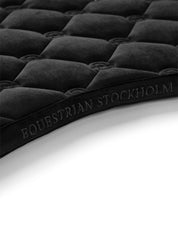Close-up view of the spine on the Black Equestrian Stockholm Velvet Jump Saddle Pad on a white background