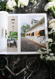 View of the open Stable Style Book-Volume III on a marble and flower background