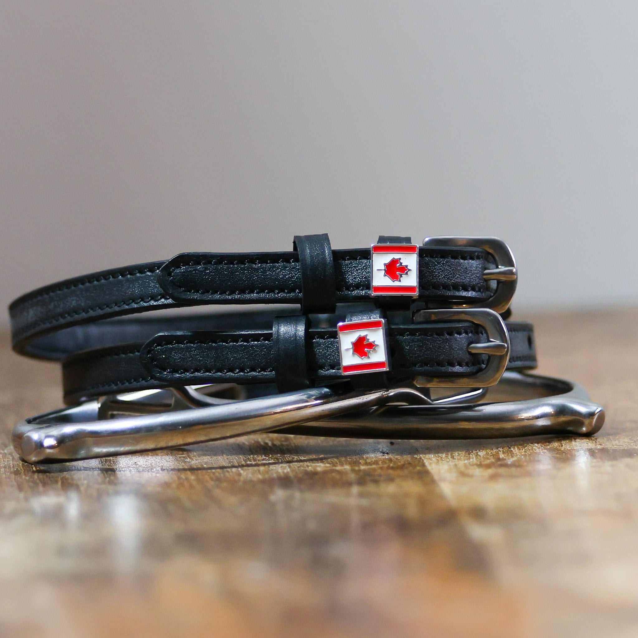 View of the Canadian flag Mane Jane Spur Straps on a wood table background