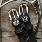 View of the Cancer Mane Jane Spur Straps  on a wood background