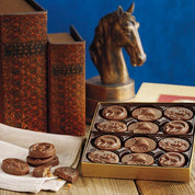 View of the Harbor Sweets Milk Chocolate Hunt Collection Gift Box on a staged background with books and horse decor