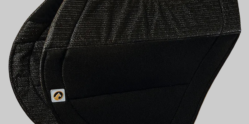 Side view of the black Ecogold Secure Cross Country Pad on a grey background