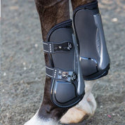 Close-up side view of a horse wearing the black TPU Professional's Choice Pro Performance Open Front Boots while standing on arena footing