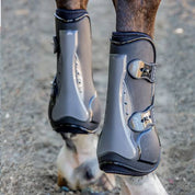 Close-up back view of a horse wearing the black TPU Professional's Choice Pro Performance Open Front Boots while standing on arena footing