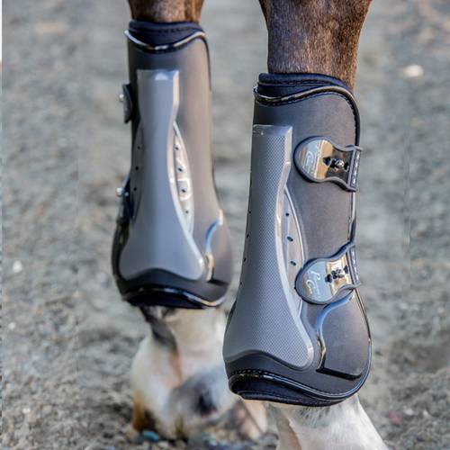 Close-up back view of a horse wearing the black TPU Professional's Choice Pro Performance Open Front Boots while standing on arena footing