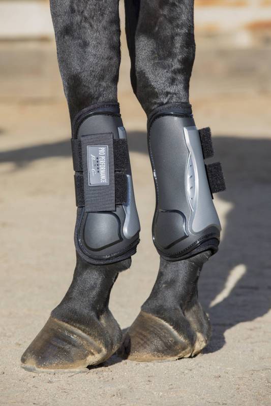 Side view of a black horse wearing the Black Hook & Loop Professional's Choice Pro Performance Open Front Boots while standing on sand