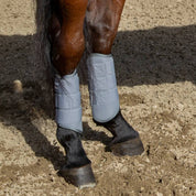 Close-up view of a bay horse wearing the Charcoal Professional's Choice Pro Performance XC Rear Boots while standing in the dirt