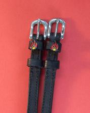 View of the Flame Mane Jane Spur Straps  on a red background