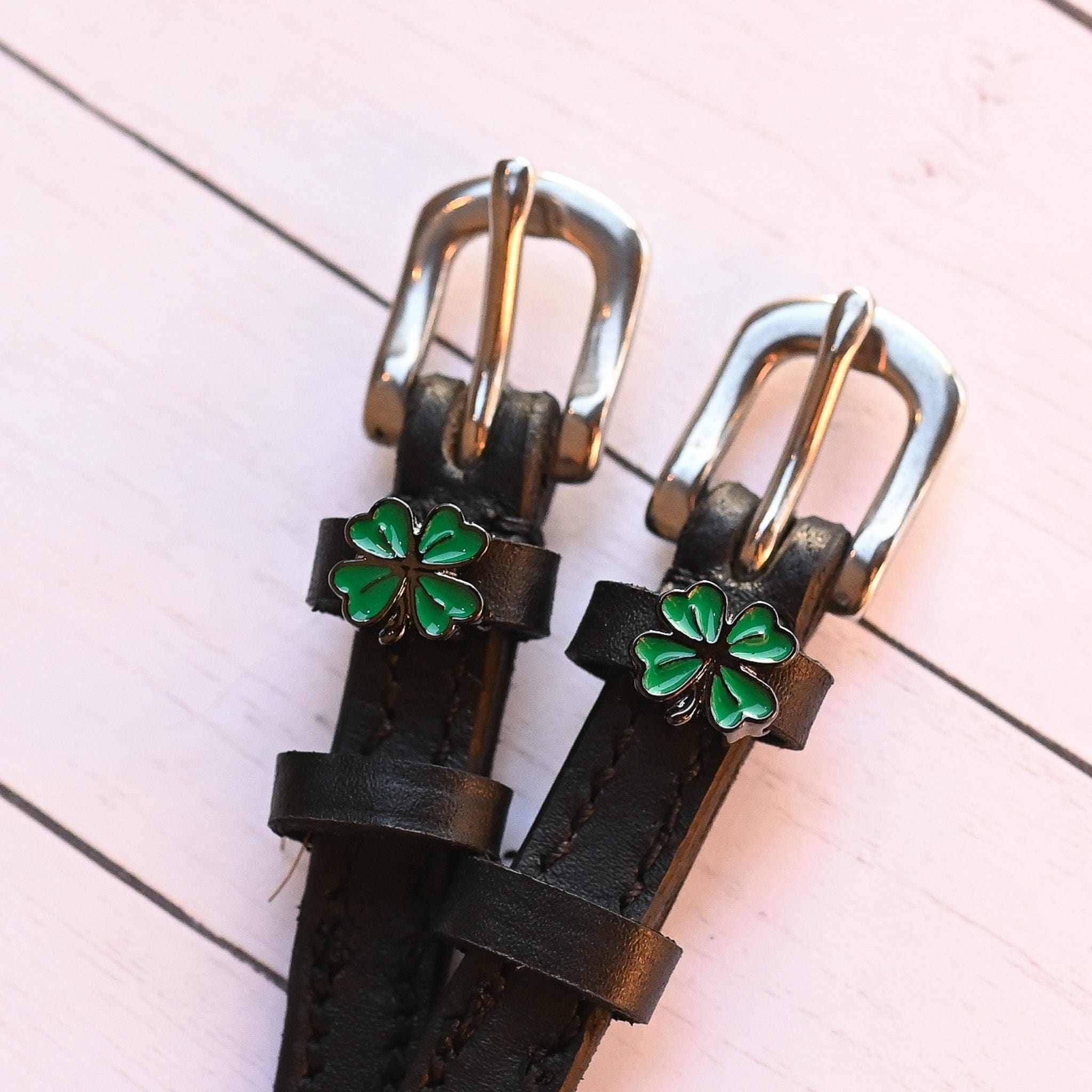 View of the 4 Leaf Clover Mane Jane Spur Straps  on a white shiplap background