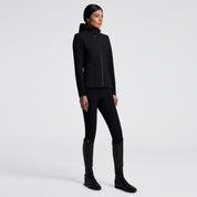Black full zip softshell jacket with hood and shoulder logo shown on model in front of plain white background