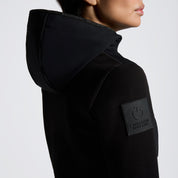 Black full zip softshell jacket with hood and shoulder logo shown on model in front of plain white background