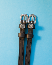 View of the Gemini Mane Jane Spur Straps on a blue background