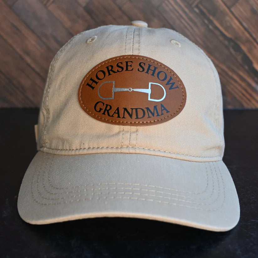 Front view of the Horse Show Grandma Dubois Cheval Baseball Hat on a wood herringbone background