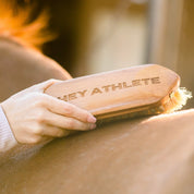 View of a female model brushing a horse with the Hey Athlete - TKEQ x SPR Natural Dandy Brush
