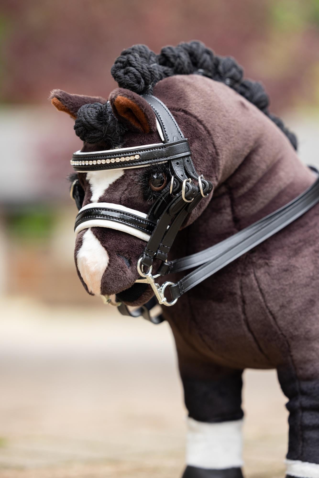 Close-up angled front view of a bay toy pony wearing the Black Toy Pony Double Bridle