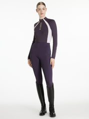 Full body front view of a female model wearing the Juniper LeMieux Philippa Mesh Base Layer with matching breeches on a plain background
