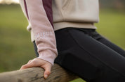 Close-up view of the sleeve of the Wild Rose LeMieux Kadie Color Block Hoodie, worn by a female model