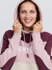 Close-up front view of a female model wearing the Wild Rose LeMieux Kadie Color Block Hoodie on a plain background